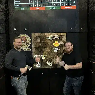 Friends enjoying axe throwing at Axe-Mania, an indoor entertainment venue in Kingwood, TX.